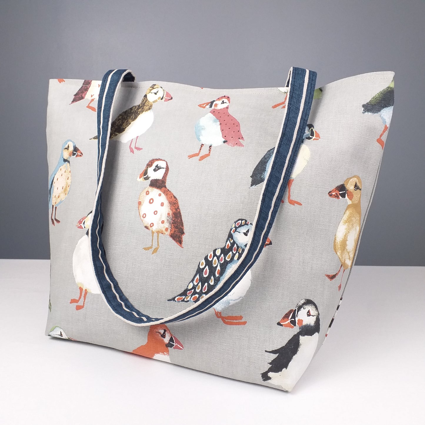 Large tote bag with multi-colour puffins design on grey background