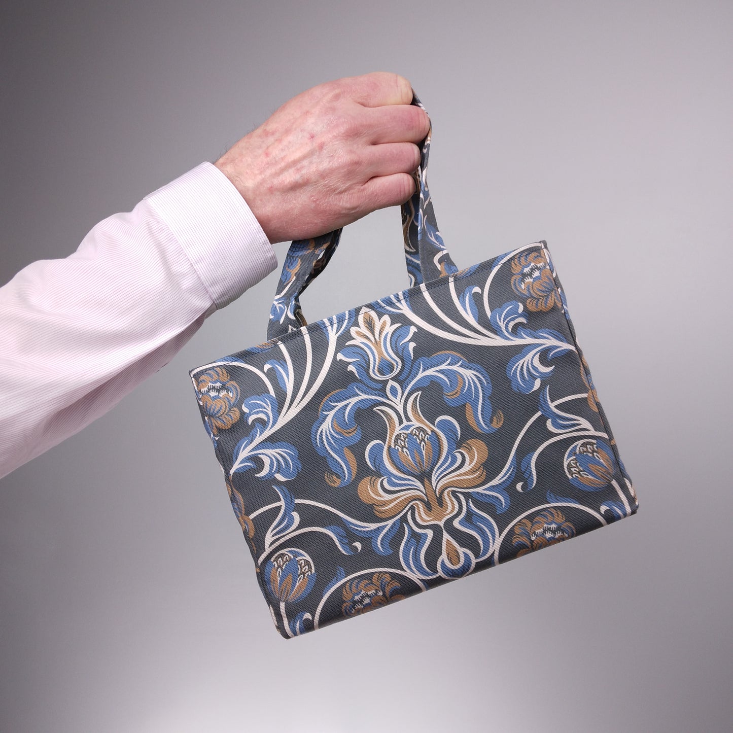 Mini tote bag with white, brown, and blue baroque style floral design on navy background