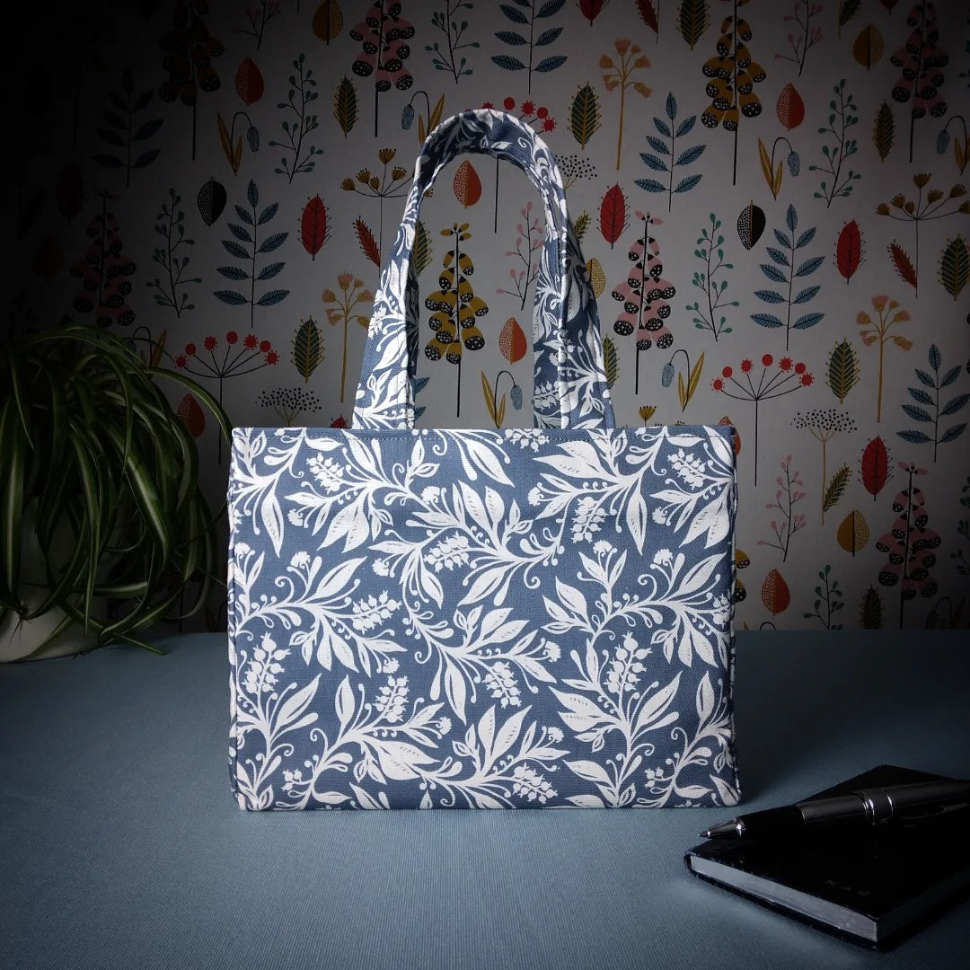 Mini tote bag with white wildflower silhouette design on dark blue background