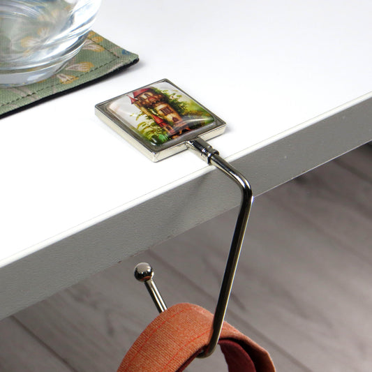 Handbag hook with glass domed image for hanging accessories on tables, ledges, and shelves