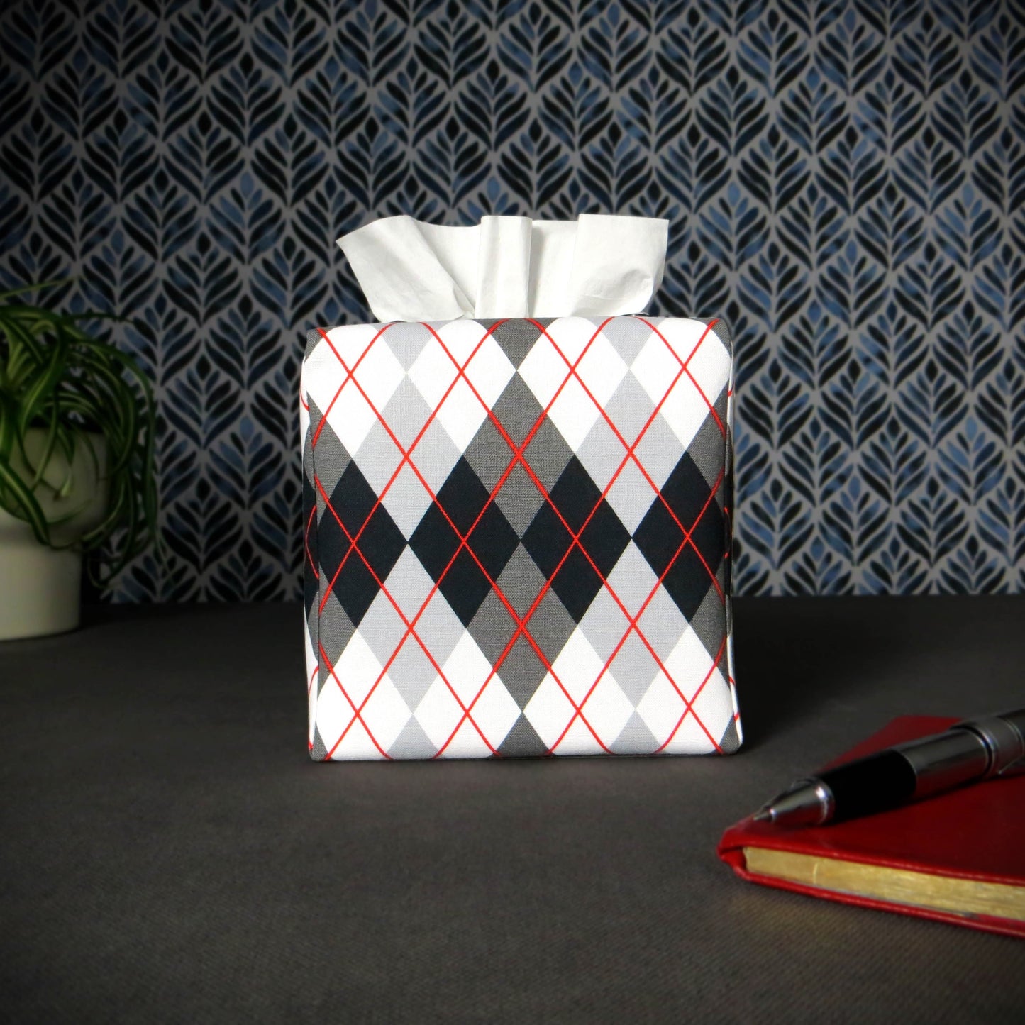 Square tissue box cover with black, grey, and red argyle pattern