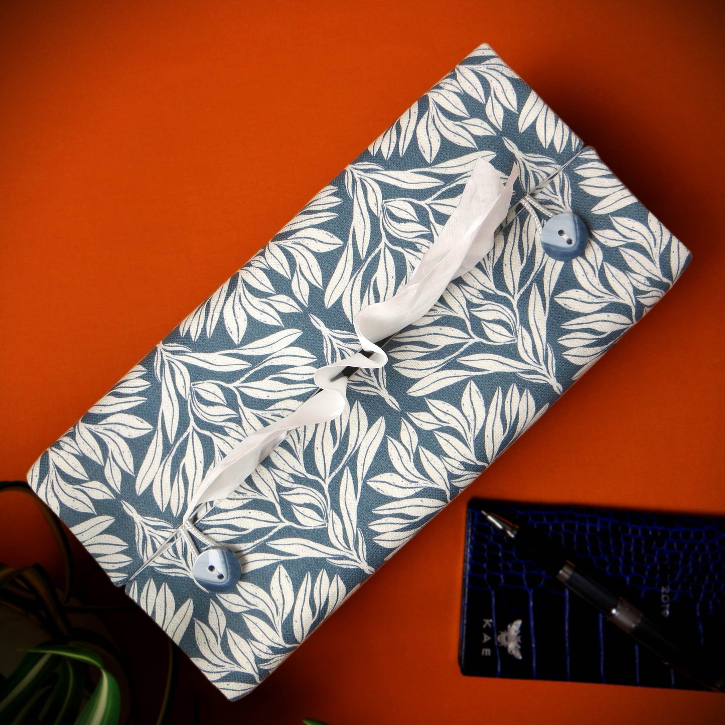 Linen rectangular tissue box cover with an off-white leaf pattern on a blue background