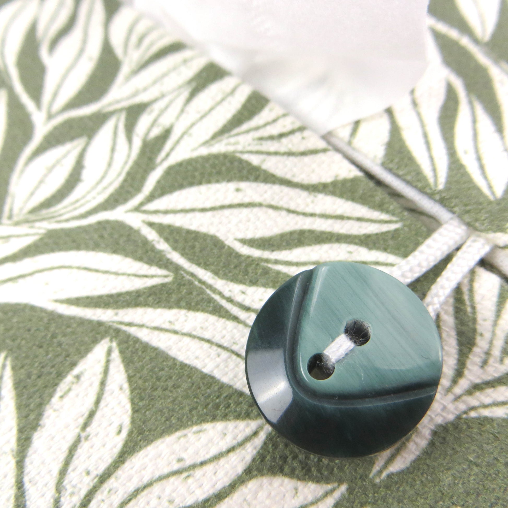 Linen rectangular tissue box cover with an off-white leaf pattern on a sage green background