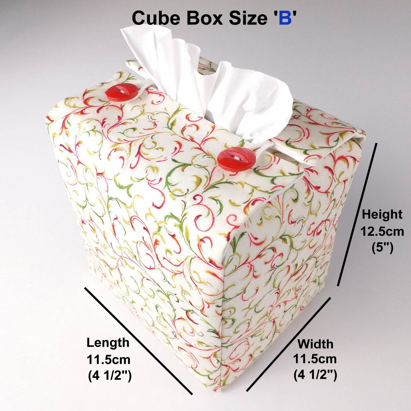 Square tissue box cover with holiday themed red and green swirls with metallic gold accent on cream colour background
