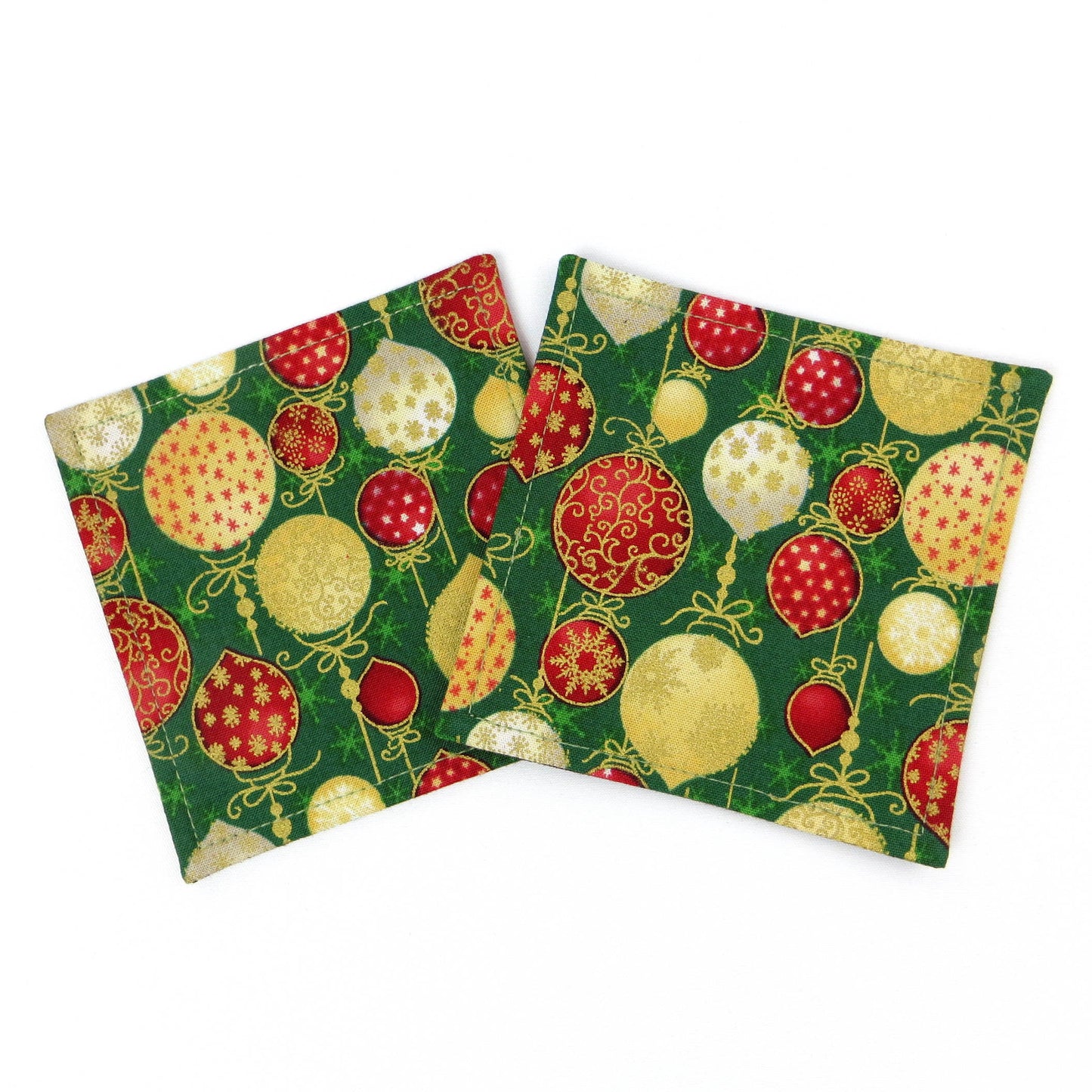 Square coasters with holiday themed red, gold, and white baubles on green background