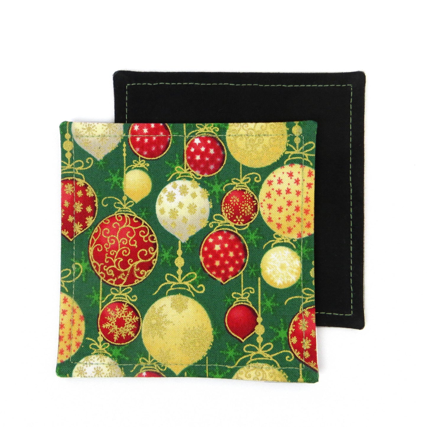 Square coasters with holiday themed red, gold, and white baubles on green background