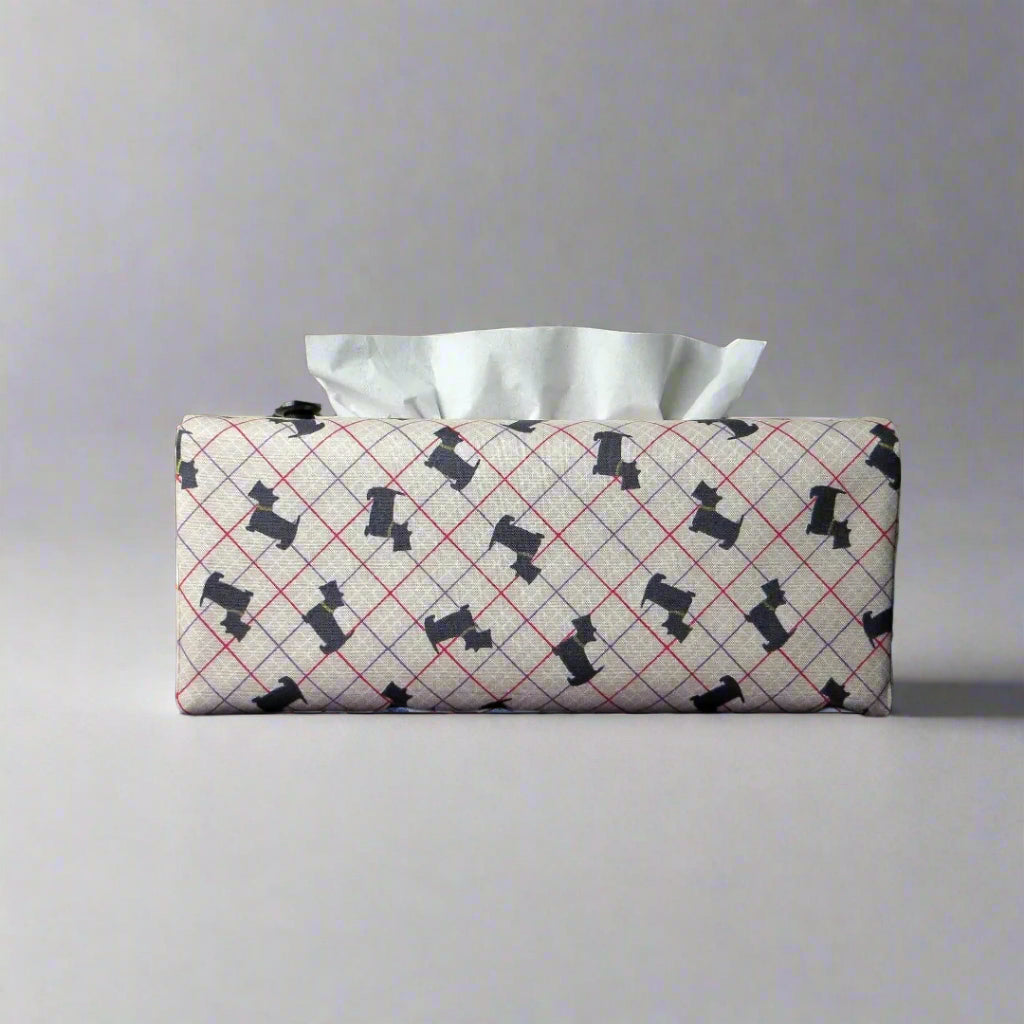 Rectangle tissue box cover with iconic black Scottish Terrier dogs with metallic gold collar design on beige background with red, purple, and white grid
