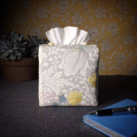 Square tissue box cover with white magnolia flowers design with blue, yellow, and grey accents