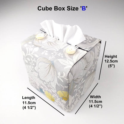 Square tissue box cover with white magnolia flowers design with blue, yellow, and grey accents