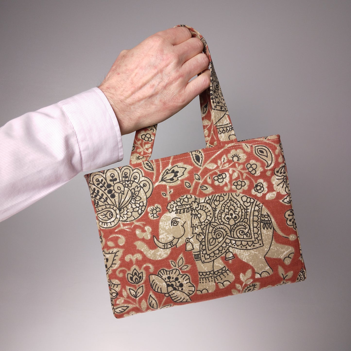 Mini tote bag with ornate taupe elephant design on red background