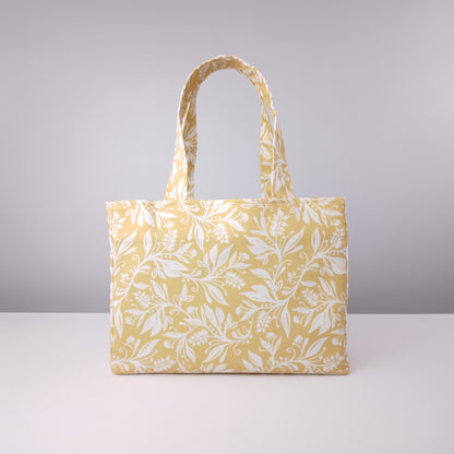 Mini tote bag with white wildflower silhouette design on yellow background