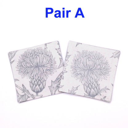 Square coasters with grey thistle design on white background