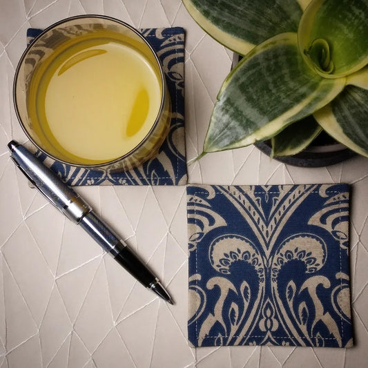 Square coasters with tan damask print on blue background
