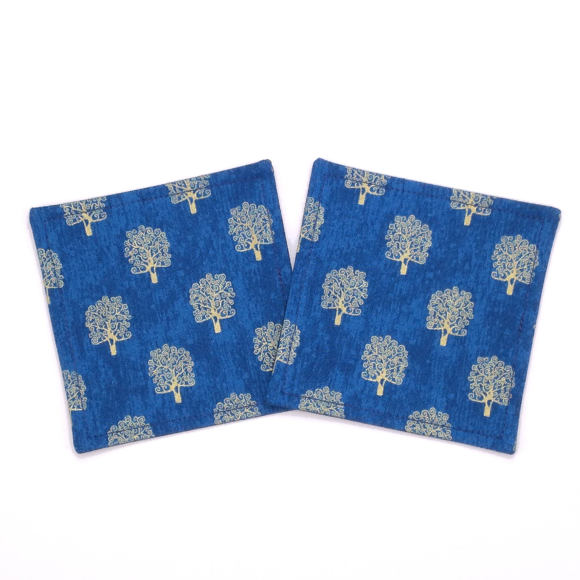 Square coasters with gold colour trees design on blue background