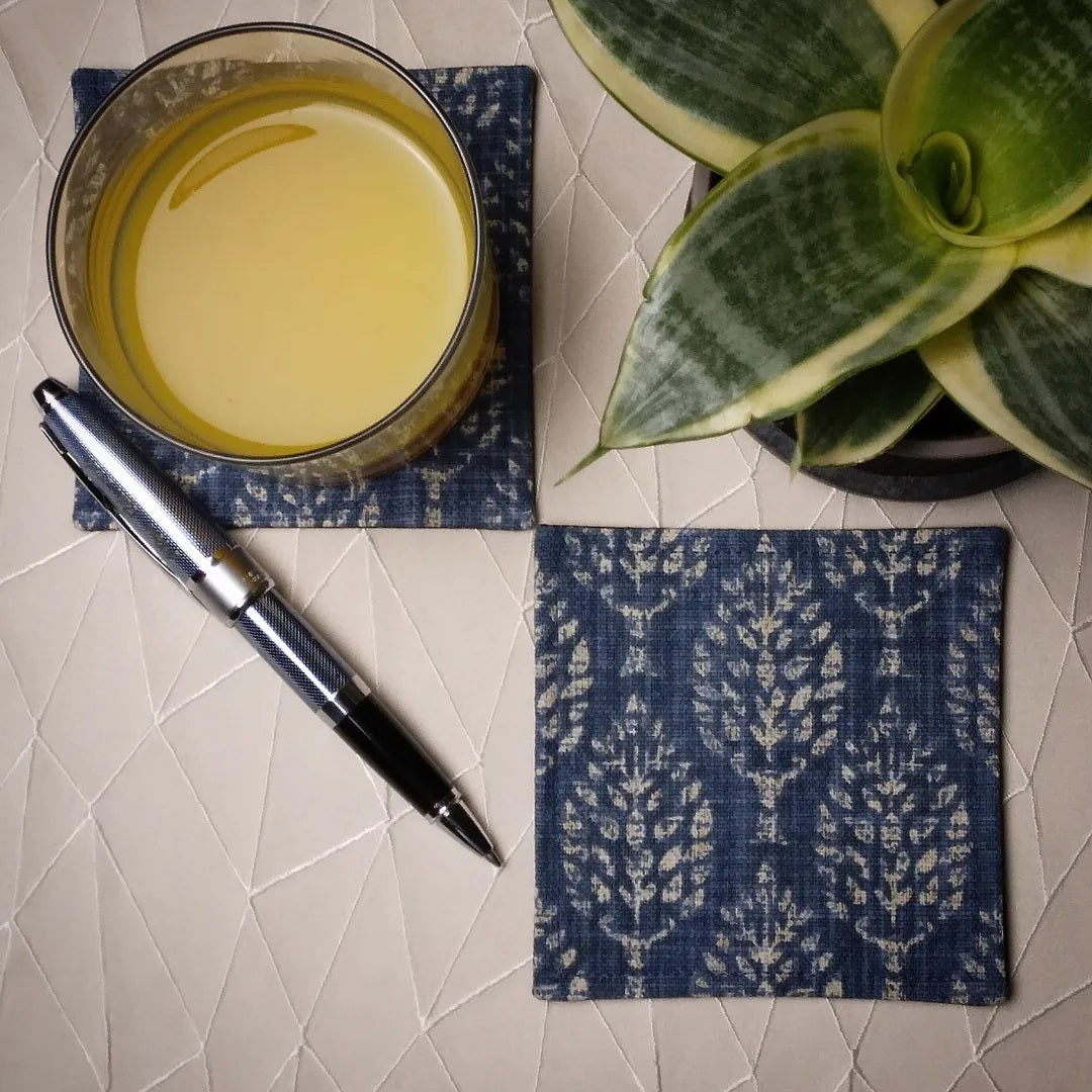 Square coasters with tan poplar trees design on blue background