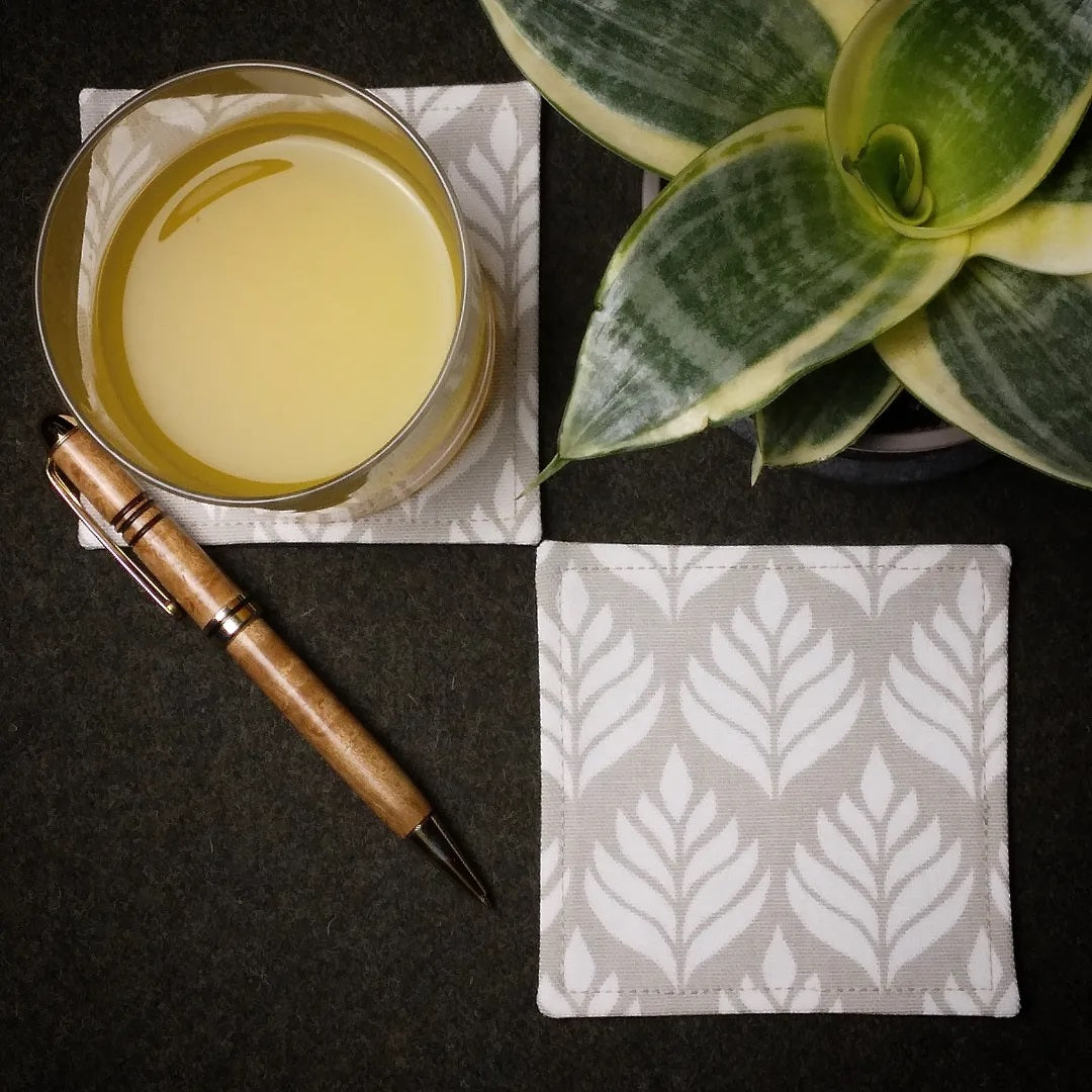 Square coasters with off-white leaf icon design on natural colour background