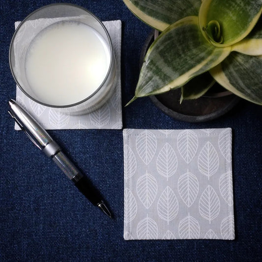 Square coasters with white leaf outline on grey background