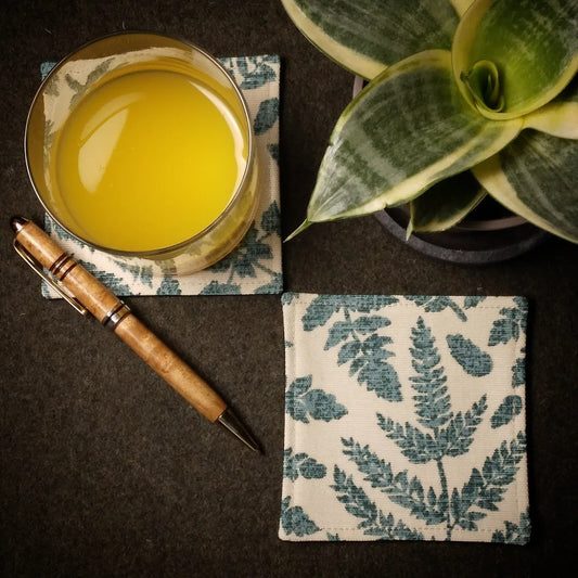 Square coasters with green fern leaves design on beige background