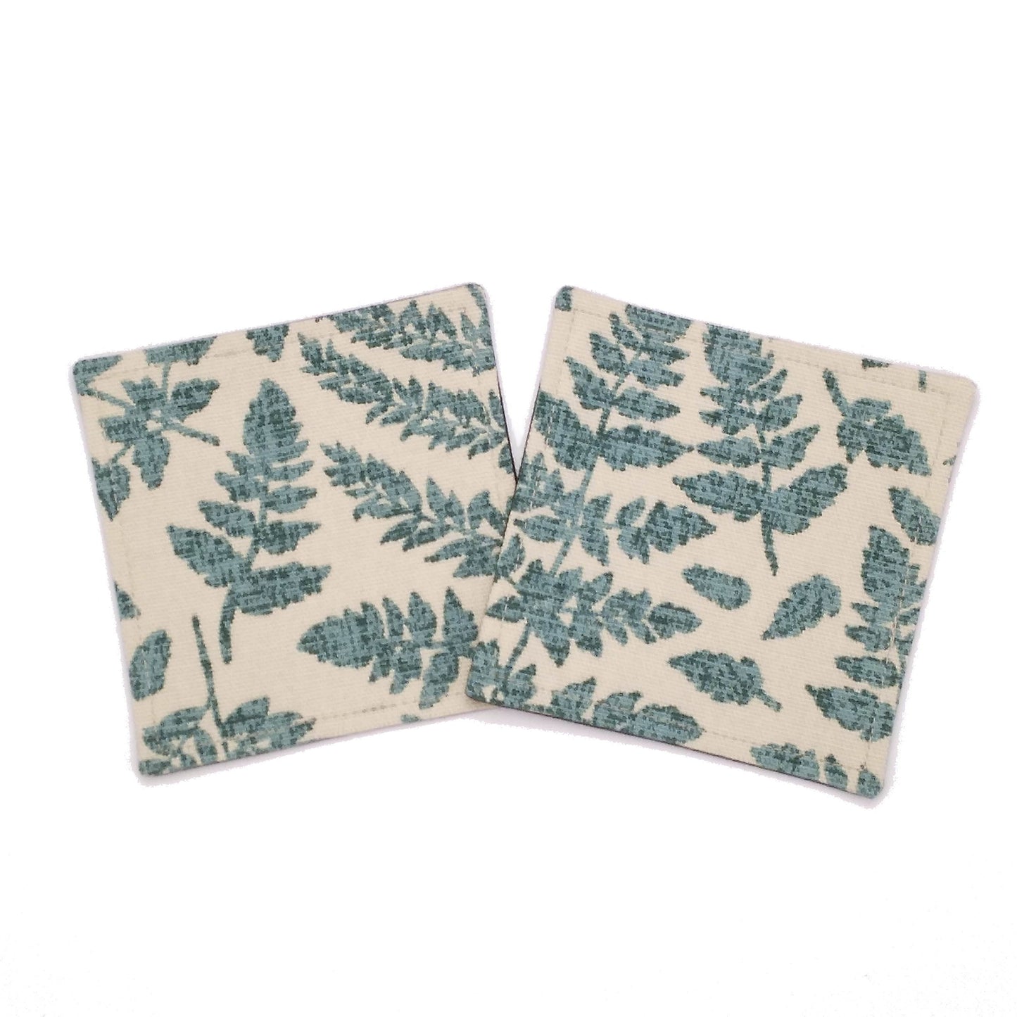 Square coasters with green fern leaves design on beige background