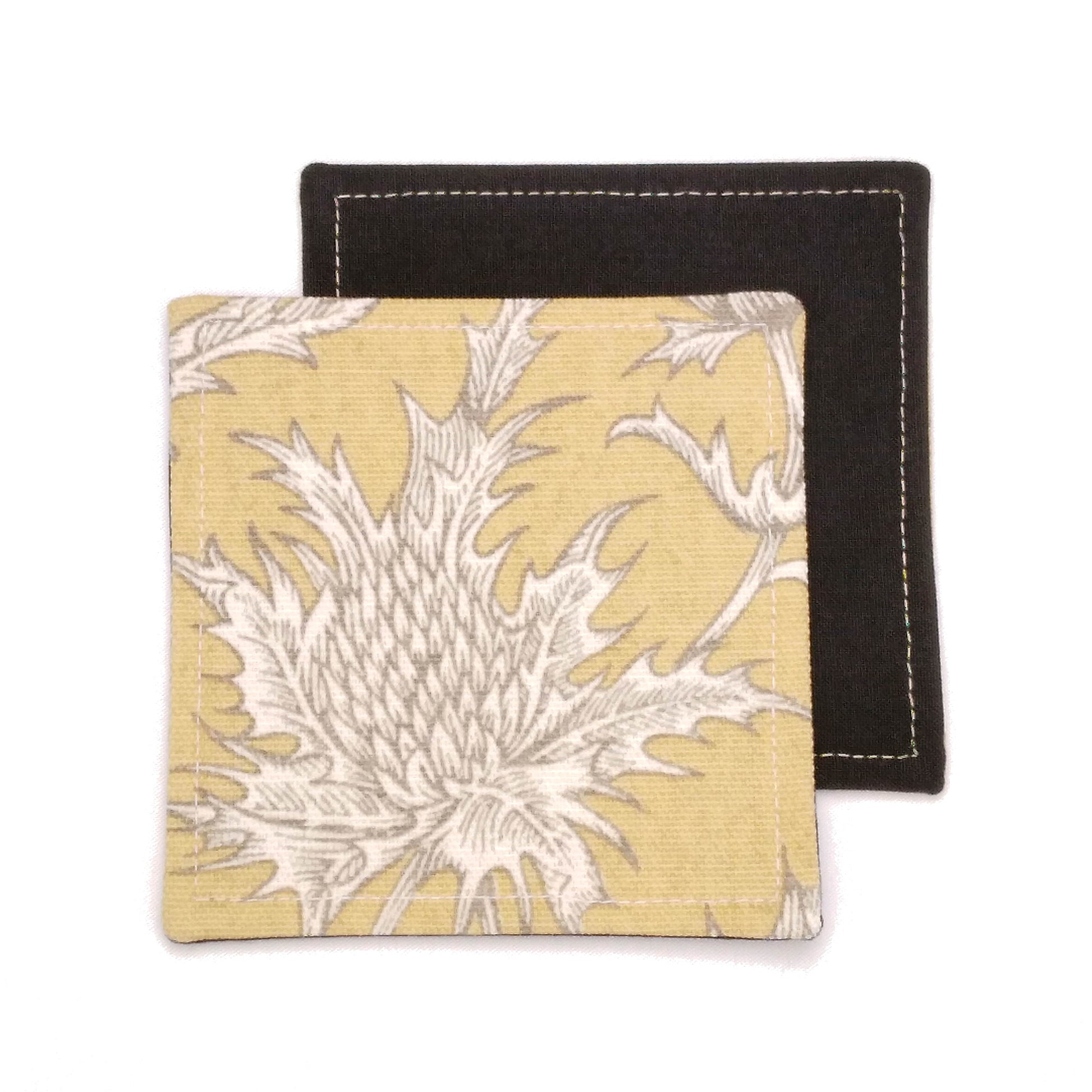 Square coasters with white thistle design on yellow background