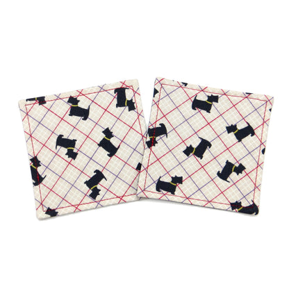 Square coasters with Scottish Terrier dogs design on beige background with red, purple, and white grid