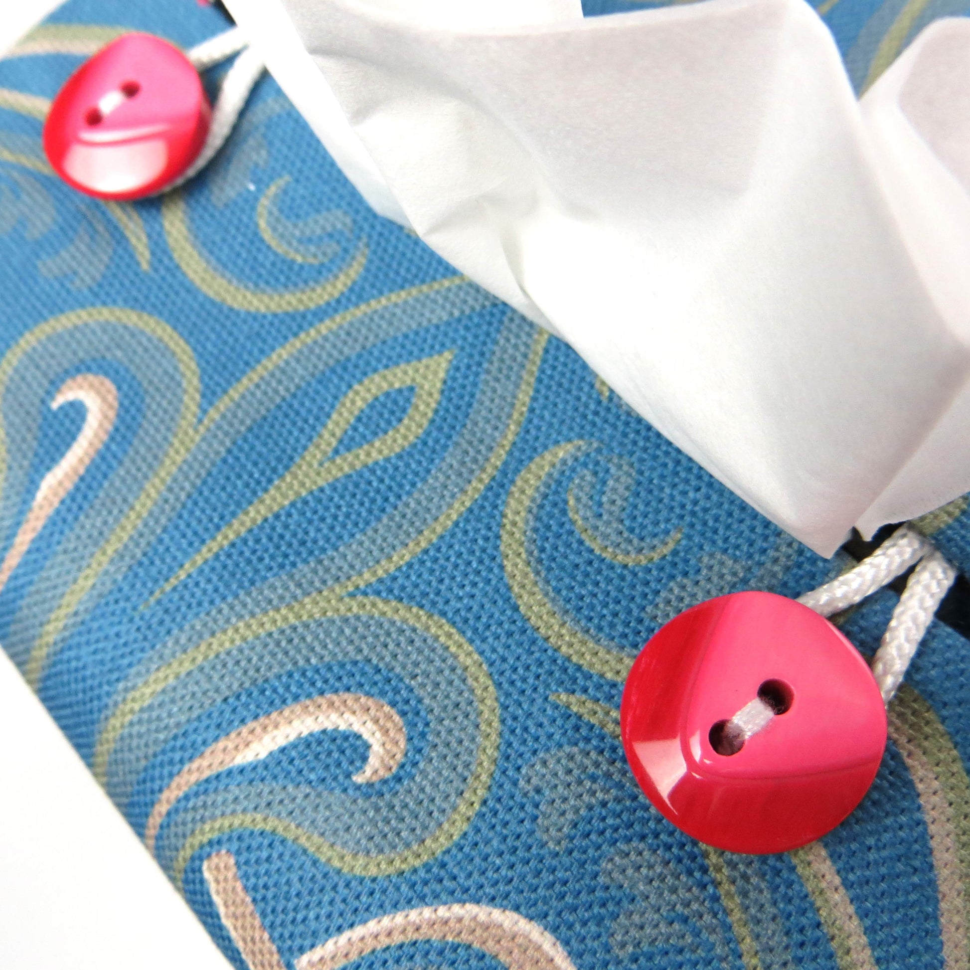 Square tissue box cover with red flowers and green Victorian embellishment on blue background