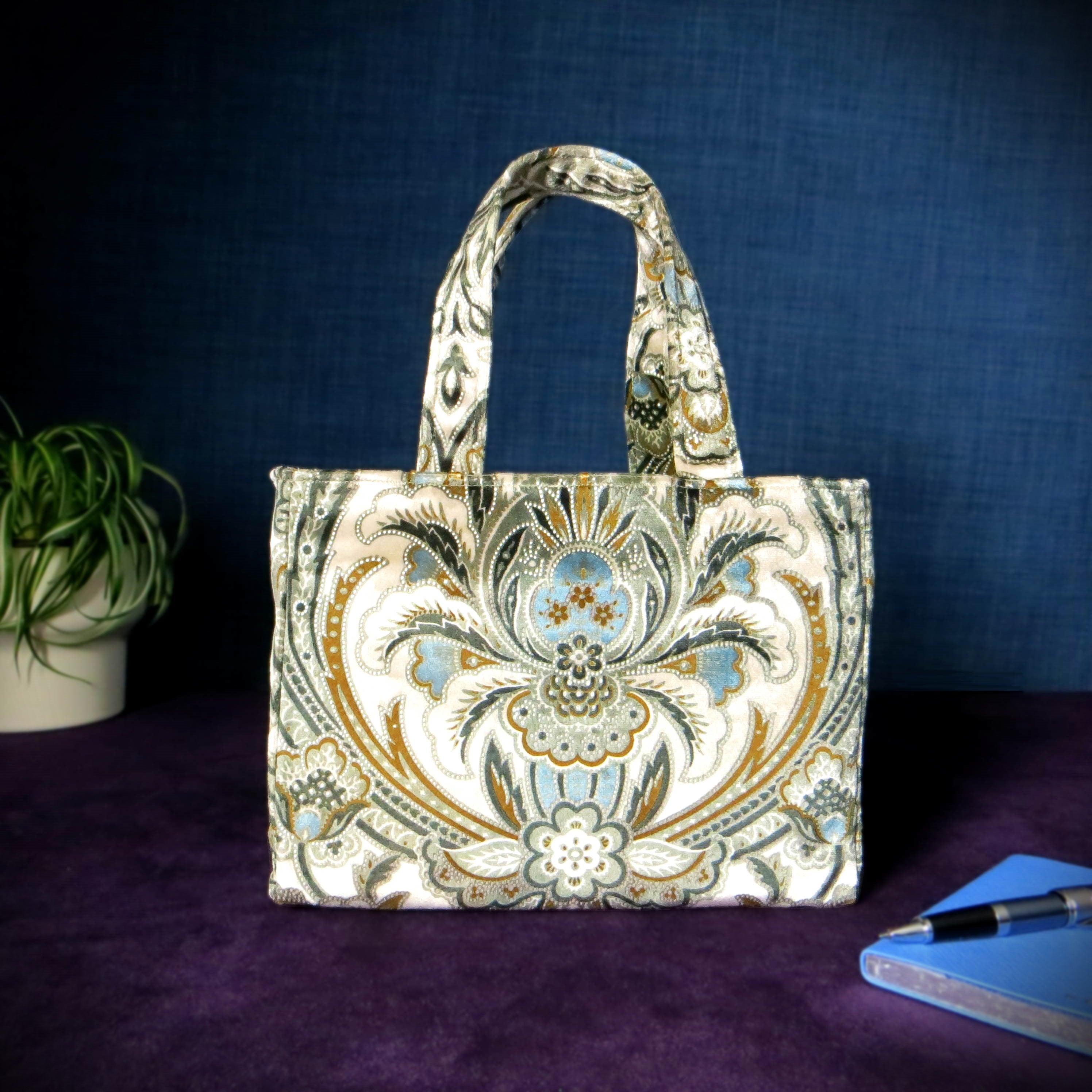 Small velvet tote bag with a floral design in blue, brown, black, and cream