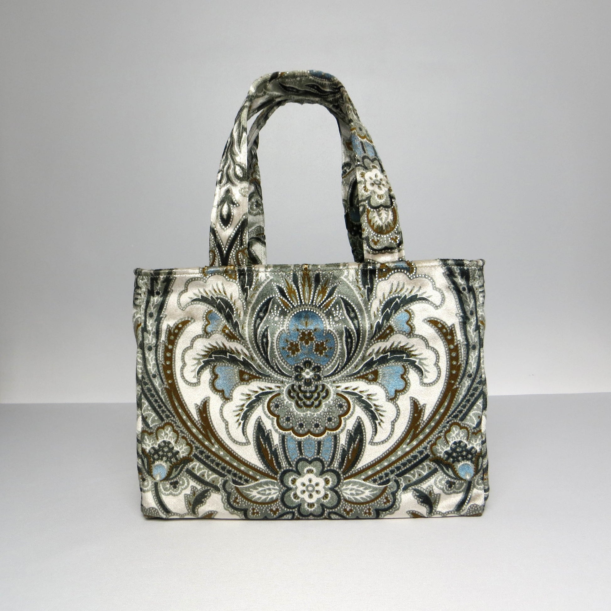 Small velvet tote bag with a floral design in blue, brown, black, and cream