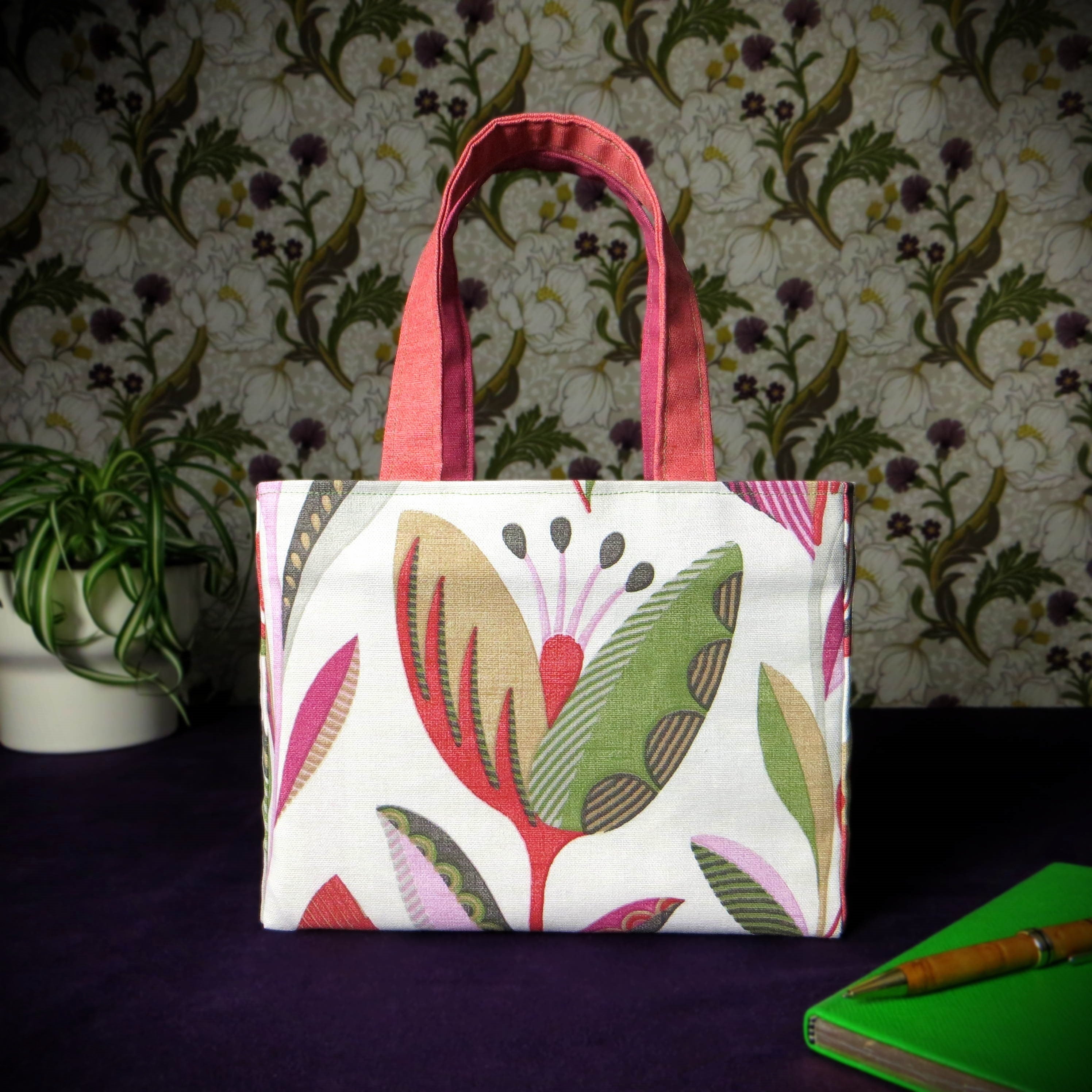 Small cotton tote bag with shades of moss green, raspberry pink, soft grey, and rhubarb red tulips on off-white background