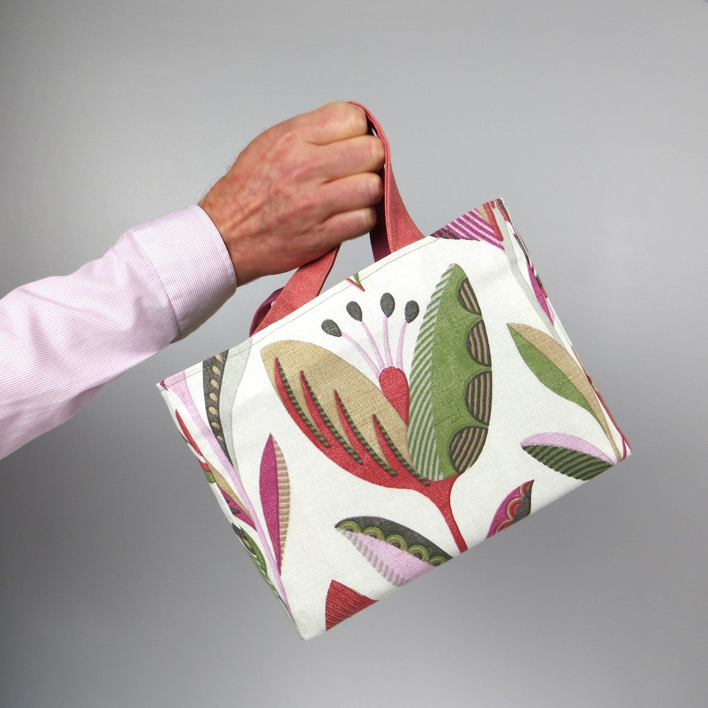 Small cotton tote bag with shades of moss green, raspberry pink, soft grey, and rhubarb red tulips on off-white background