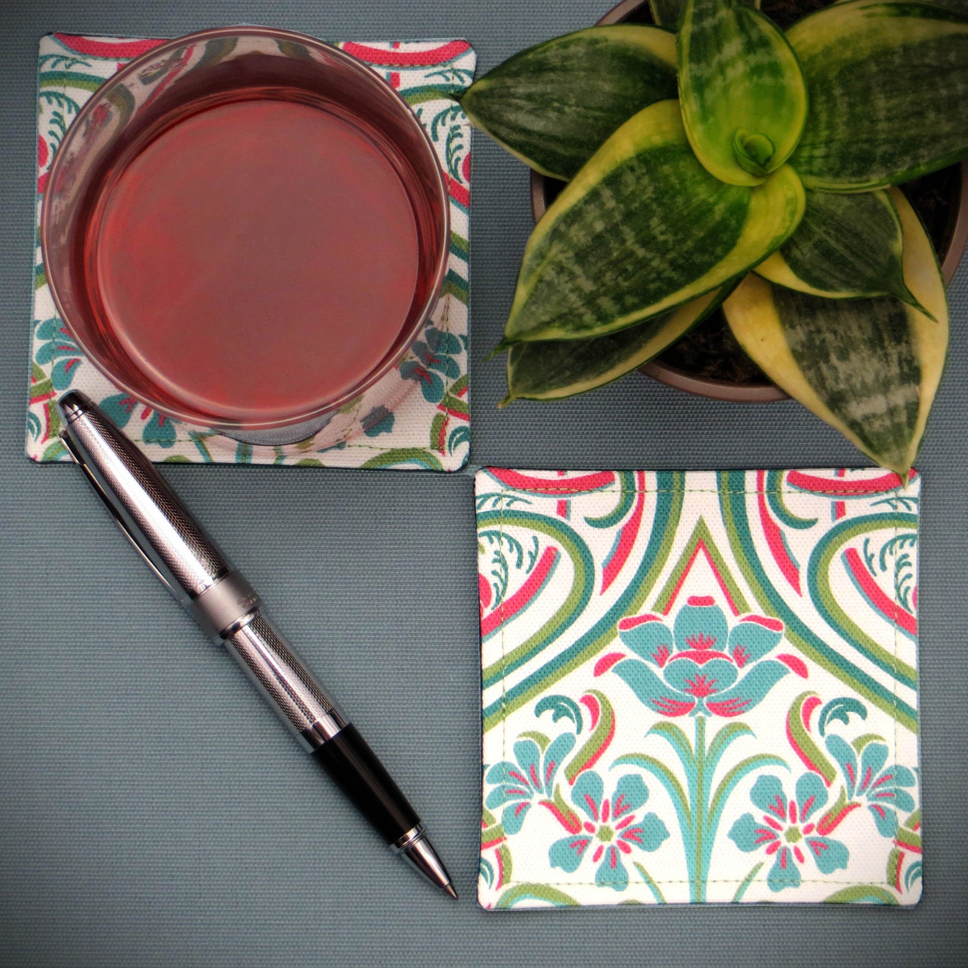 Set of 2 handmade coasters with blue flowers and elegant teal and red Victorian style accents on a white background