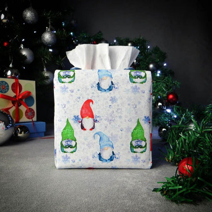 Square tissue box cover with holiday themed red, green, and blue gnomes design on white and blue snowflake pattern background