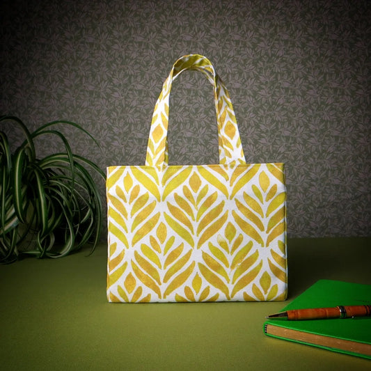 Mini tote bag with yellow watercolour style leaf pattern on background