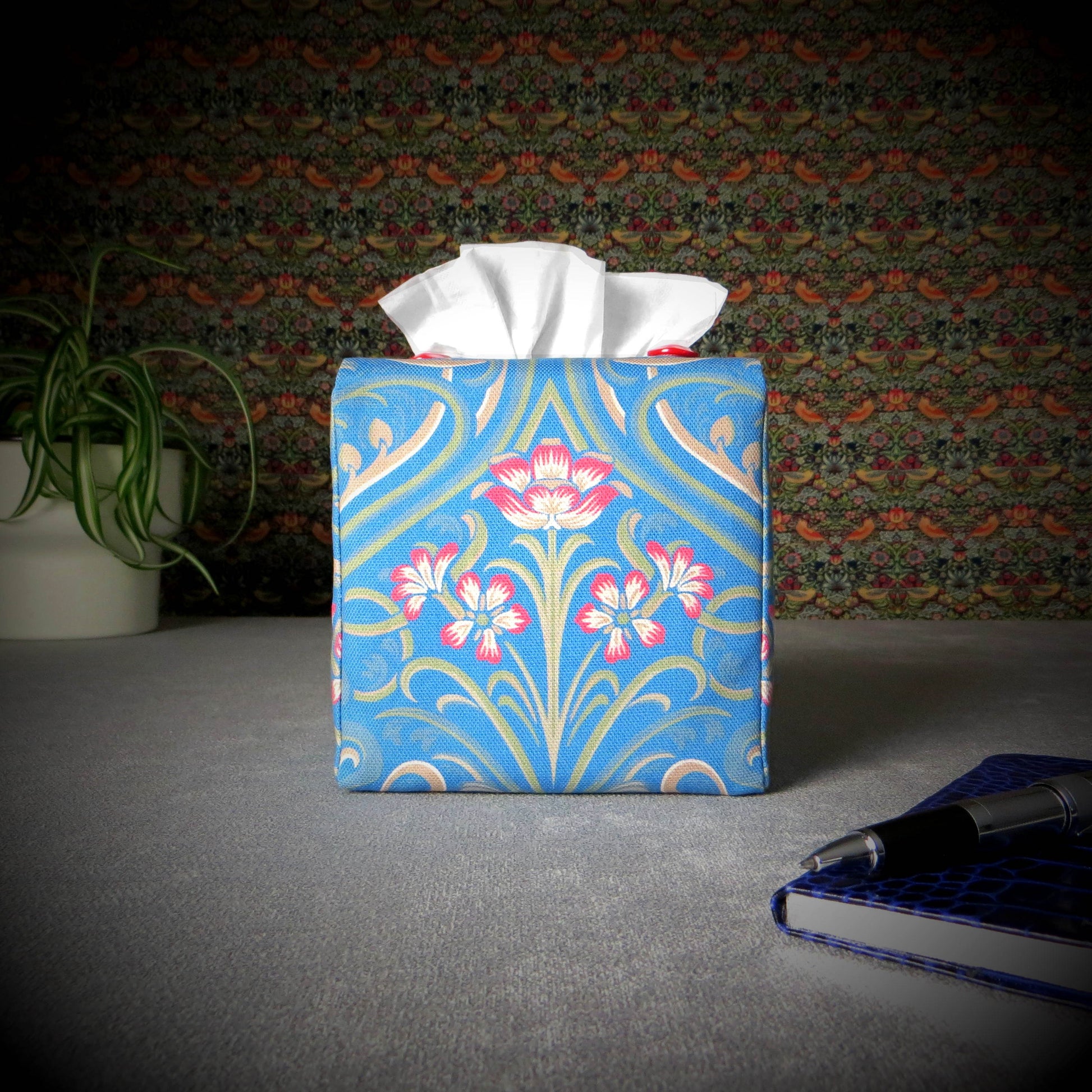 Square tissue box cover with red flowers and green Victorian embellishment on blue background